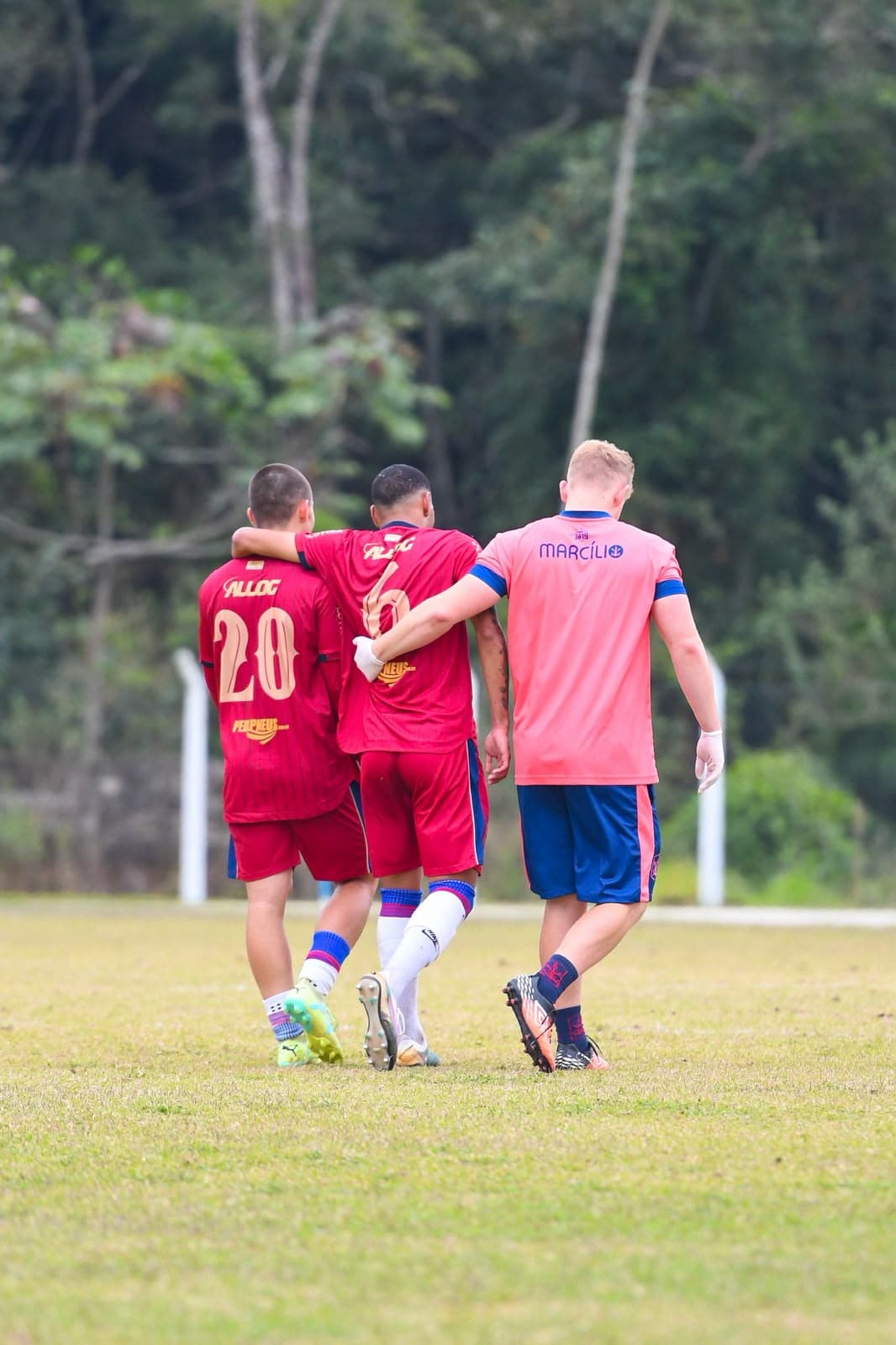 Igor Betinelli auxiliando um atleta a caminhar após lesão